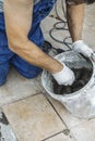 Spatula lies in a bucket with glue for tiles. worker spackles tile, selective focus Royalty Free Stock Photo