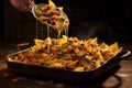 spatula lifting a portion of cheesy nachos from baking dish