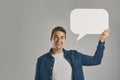 Speak your mind. Studio portrait of a young man holding a speech bubble against a grey background.