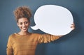 Speak your truth. Studio shot of a young woman holding a speech bubble against a grey background.