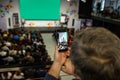 Speaker at Business Conference and Presentation. Audience at the conference hall. The man keeps a record on the smartphone. Royalty Free Stock Photo