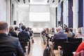 Speaker giving a talk in conference hall at business event. Rear view of unrecognizable people in audience at the Royalty Free Stock Photo