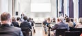 Speaker giving a talk in conference hall at business event. Rear view of unrecognizable people in audience at the Royalty Free Stock Photo