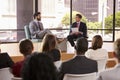 Speaker and interviewer in front of audience at a seminar