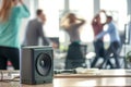 speaker on office desk, blurry colleagues unwinding with afterwork dance Royalty Free Stock Photo