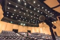 Speaker`s microphone blurred in blurry auditorium music concert hall background or seminar meeting room in educational business