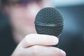 Speaking in the microphone: Young man with blurry face is taking into the microphone Royalty Free Stock Photo