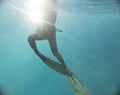 Spearfishing man with flashlight in lake. Underwater