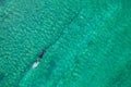 Spearfishing scuba diver in tropical exotic sea, ocean turquoise clear water. Man swimming hunting exotic fish, poaching. Top view Royalty Free Stock Photo