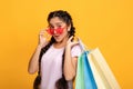 Indian woman in glasses holding colorful shopping bags at studio Royalty Free Stock Photo