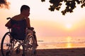 Special child on wheelchair on the sea beach with sunset on travel time Royalty Free Stock Photo