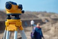 Special device level for surveyor builders, geodesy equipment close up in front of a ground work with people on blurred backgrou