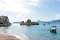 Special different rock in the adriatic sea in a small coast village in Budva. Small boats in the beach in turquoise blue water and