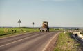 Special equipment stands on side of the road in countryside. Nearby, livestock will fall on a green meadow