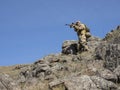 Special forces professional sniper aiming at the enemy in the mountains. Ambush in the mountains. Concept of modern Royalty Free Stock Photo