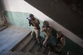 Modern warfare soldiers ascent stairs in combat