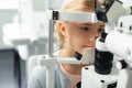 Girl looking into special glasses while having eye sight consultation Royalty Free Stock Photo