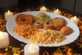 Indian Tasty Mix Snacks Plate. Candlelights and Petals. Mixed food. Traditional India tasty snacks. Season of festivals. Royalty Free Stock Photo