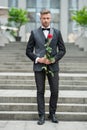 special occasion formalwear. grizzle man with rose for special occasion. tuxedo man outdoor