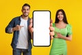 Special Offer. Smiling Middle Eastern Couple Demonstrating Blank Smartphone With White Screen