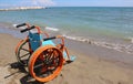 Special orange wheel chair on the beach Royalty Free Stock Photo