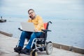 a special person with disabilities by the sea with a laptop Royalty Free Stock Photo