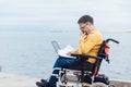 a special person with disabilities by the sea with a laptop Royalty Free Stock Photo