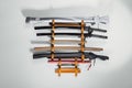 Special stand on the white wall for training swords made of oak wood and iron. Traditional Japanese training weapons for Royalty Free Stock Photo