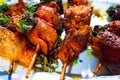 Close-up of crispy chicken and pork skewers with vegetables and special sauce, prepared for outdoor picnic Royalty Free Stock Photo