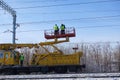Special train with a landing crane for service and repair of electrical networks on the railway. Workers doing service work on