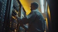 It specialist checking servers in a data center at night, ensuring smooth operation and preventing potential issues Royalty Free Stock Photo