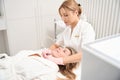 Specialist cosmetologist performs procedure in decollete area using CO2 laser