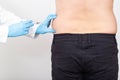 A specialist doctor makes slimming injections into the lateral fat layer. Fat burning on the sides, liposuction