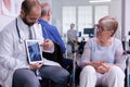 Specialist doctor showing x ray to elderly woman in wheelchair Royalty Free Stock Photo