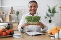 Specialist holding container with microgreens in workplace