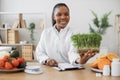 Specialist holding container with microgreens in workplace