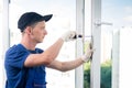 A specialist in installing plastic windows finishes work by screwing additional equipment to the window Royalty Free Stock Photo