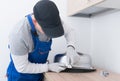 Specialist in protective clothing, installs mounting clips to fix the metal sink