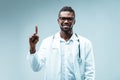 Specialist raises finger, cautions, smiles, wears glasses Royalty Free Stock Photo