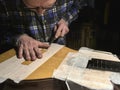 The specialist removes varnish from the body of the guitar.