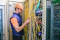 Specialist restores the Internet connection. The engineer works with computer switching equipment. Professional communications guy