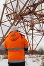 specialist in signal clothing watches the work at height. man working on high telecommunication tower. Royalty Free Stock Photo