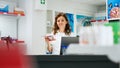 Specialist woman working at pharmacy counter with medicaments