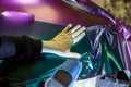 A specialist in wrapping a car with chameleon-colored vinyl film in the process of work.