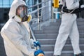 Specialists in hazmat suits cleaning disinfecting coronavirus cells epidemic, pandemic health risk