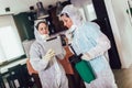 Specialists in protective suits do disinfection or pest control in the apartment