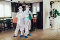 Specialists in protective suits do disinfection or pest control in the apartment