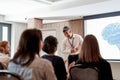 Specialized in business education. Audience applauding asian male speaker after his talk at business meeting, forum at Royalty Free Stock Photo