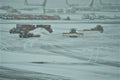 Specialized trucks plows shovel snow from tarmac for Delta planes