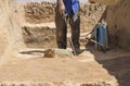 Specialized worker sprays an half-buried bronze piece at archaeological site